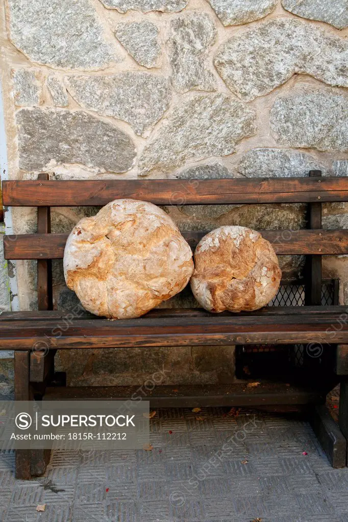 Spain, White bread loaf on wooden bench