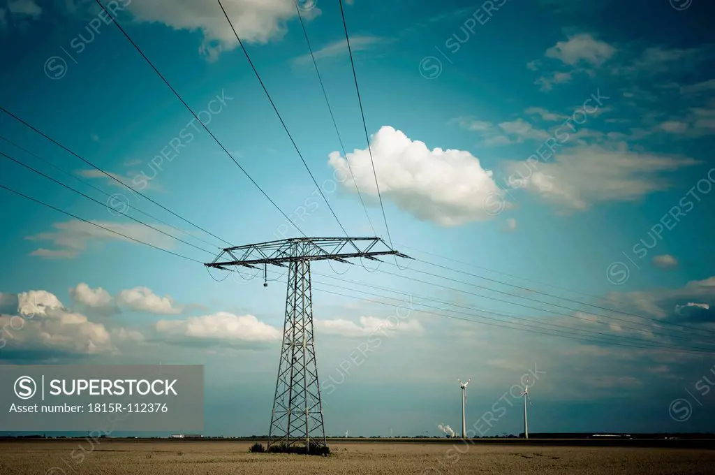 Germany, Saxony, Power lines and wind turbine in wind park