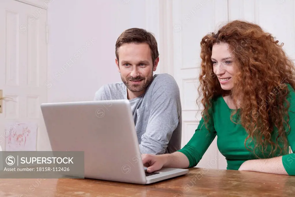 Germany, Berlin, Couple using laptop at home