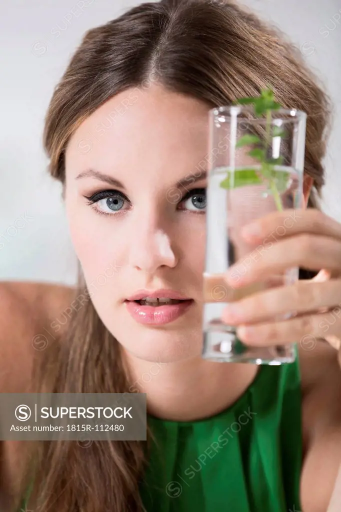 Germany, Young woman holding glass of water