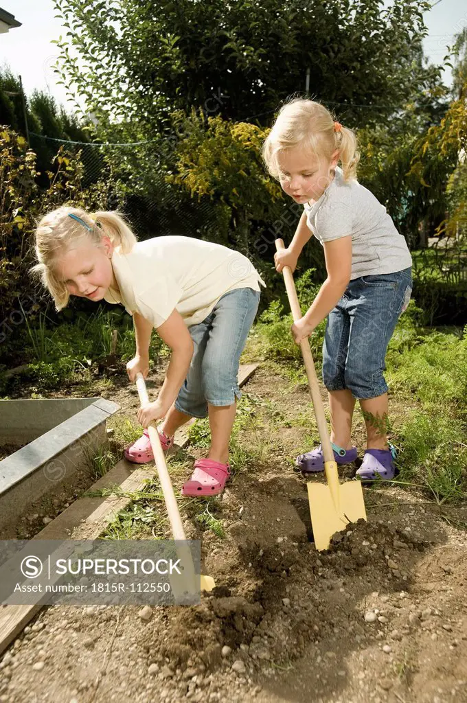 Germany, Bavaria, Girls working in vegetable garden