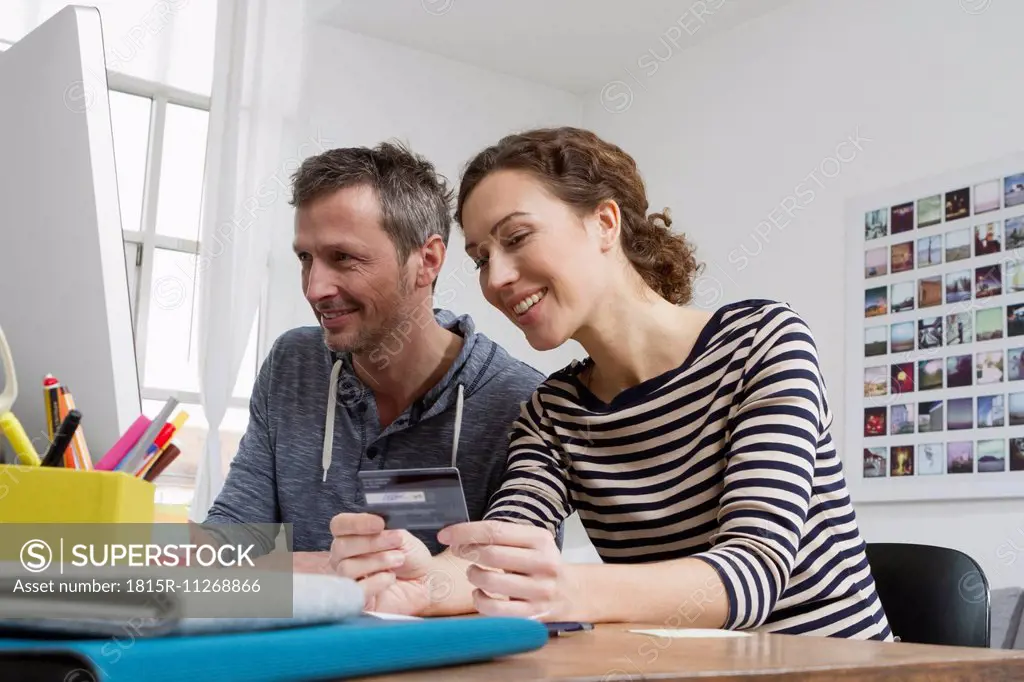 Couple at home sitting at desk shopping online