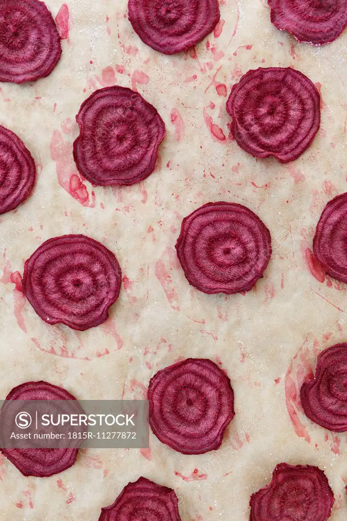 Baked slices of beetroots on baking paper, detail