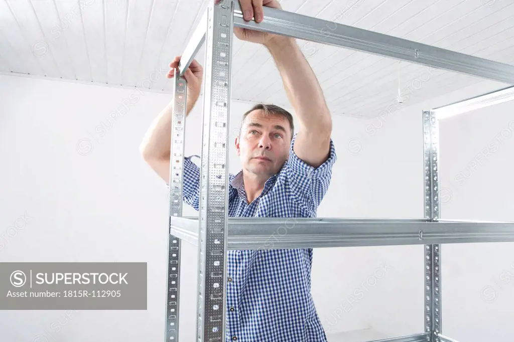 Mature man building shelf