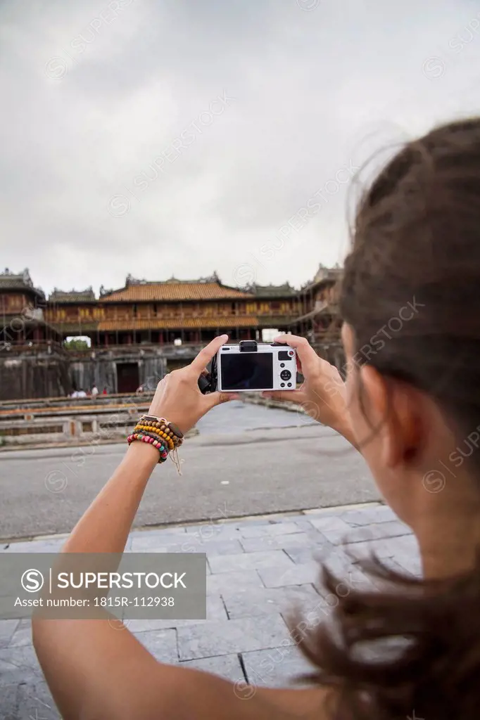 Vietnam, Hue, Young woman taking photograph of Hue Citadel