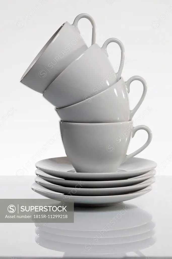 Stack of white coffee cups in front of white background