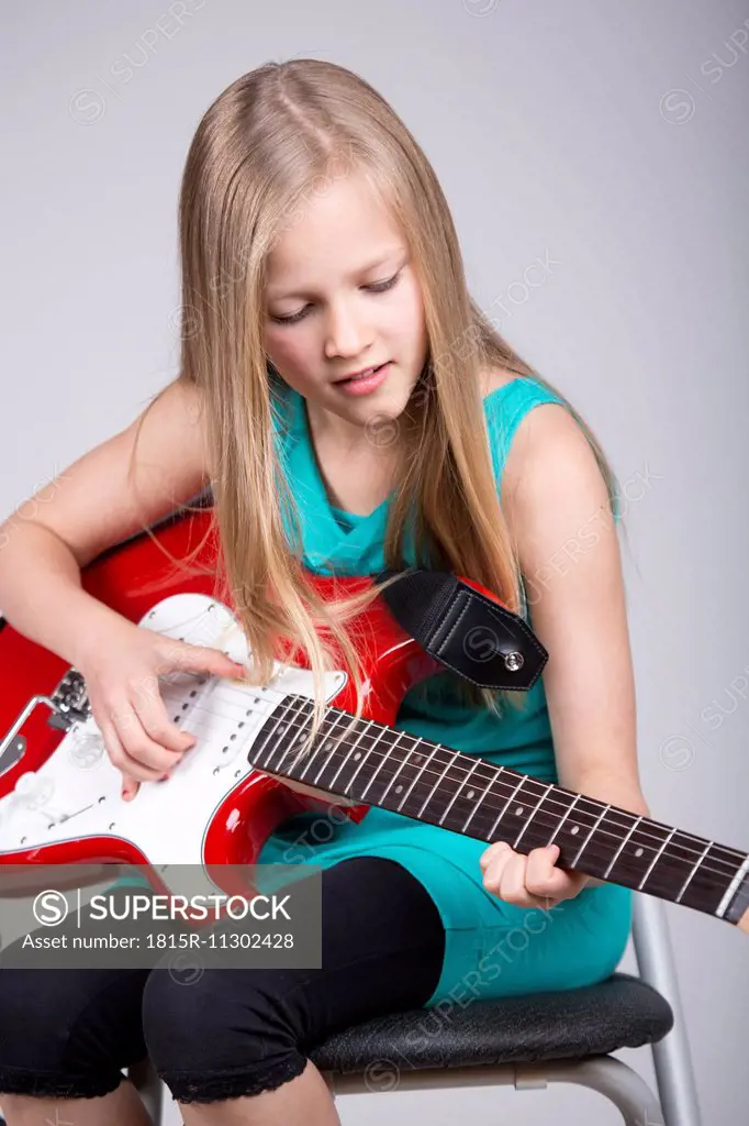 Blond girl playing guitar