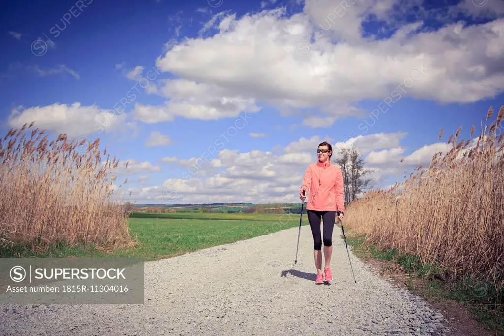 Female Nordic walker on the move through the rural landscape