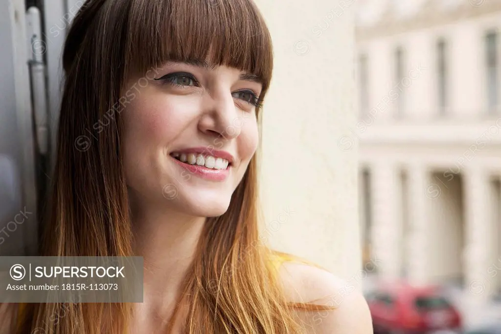 Germany, Berlin, Young woman looking away, smiling