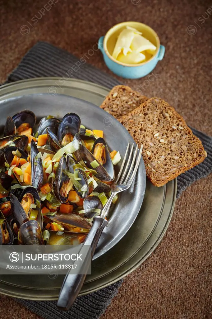 Mussel, whole grain bread with butter in bowl on table