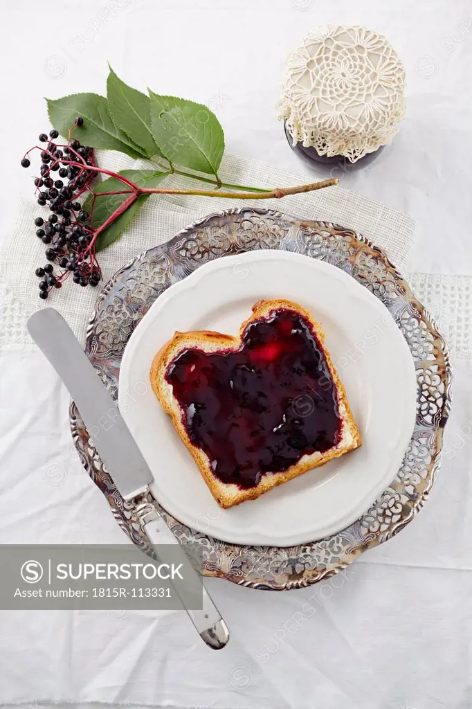 Elderberry jam with white bread on plate