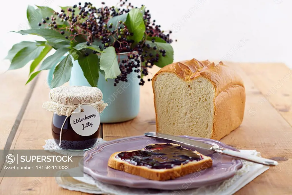 Elderberry jam with white bread on wooden table