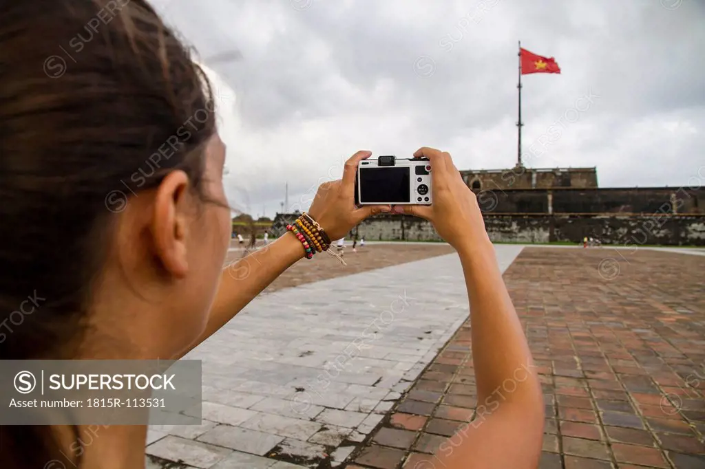 Vietnam, Hue, Young woman taking photograph of Hue Citadel