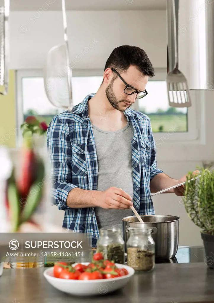 Young man cooking in kitchen at home