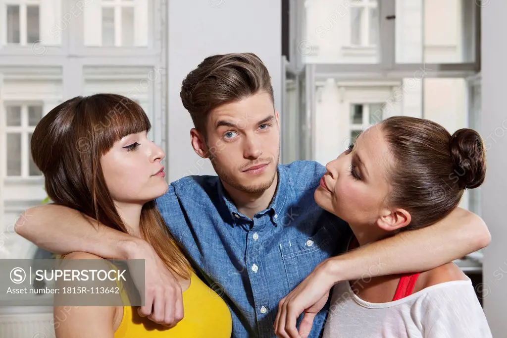 Germany, Berlin, YoungYoung man with arm around two friends