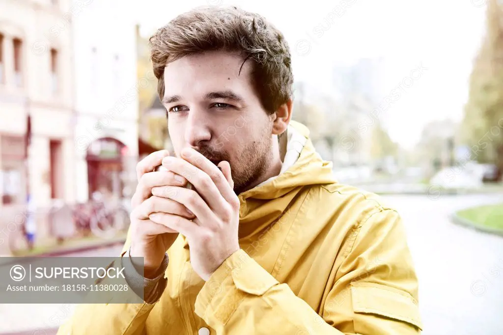 Portrait of young man holding coffee cup