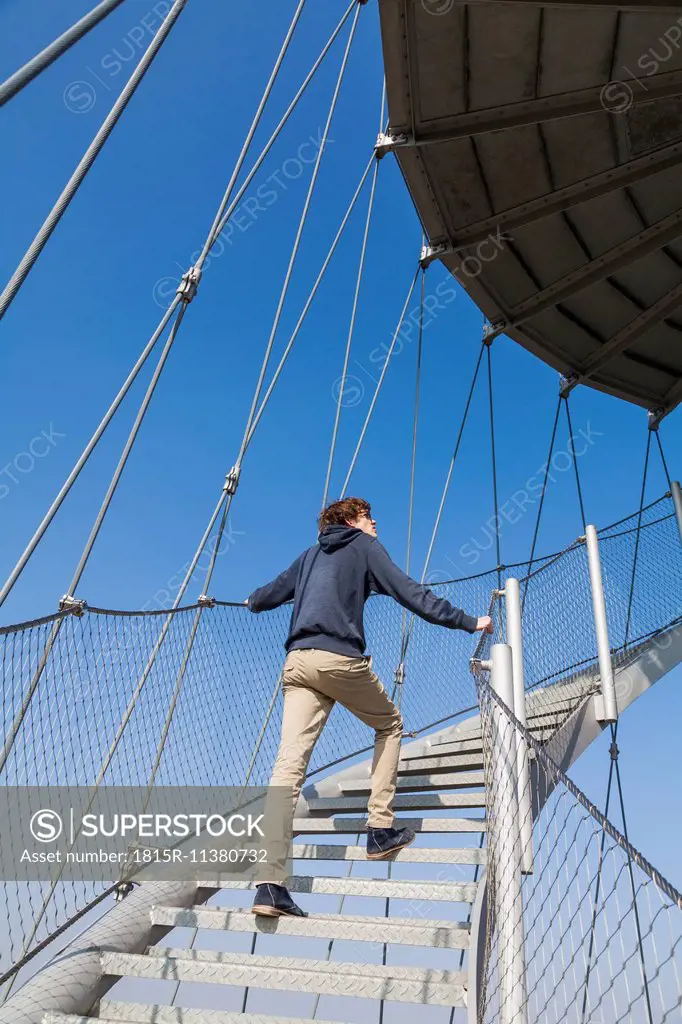 Germany, Stuttgart, Teenage boy climbing stairs of Killesberg Tower