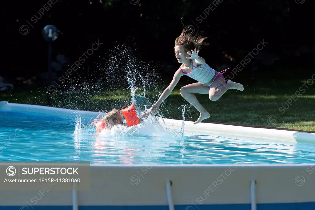 Italy, Tuscany, Children jumping into swimming pool