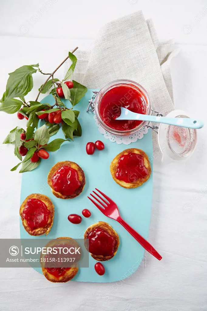 Cornel cherry jam with pancakes on chopping board