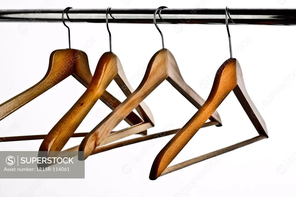Close up of coathangers on clothes rail against white background