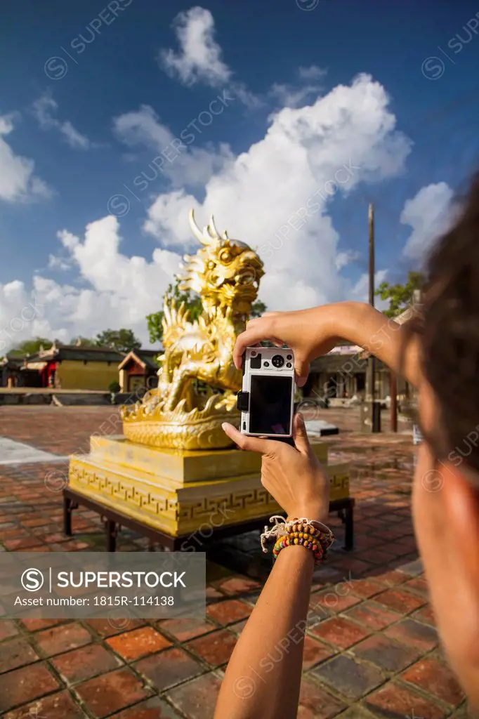 Vietnam, Hue, Young woman taking photograph of Can Chanh palace