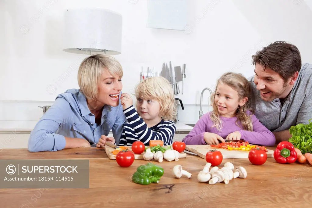 Germany, Bavaria, Munich, Family preparing food while boy feeding mother