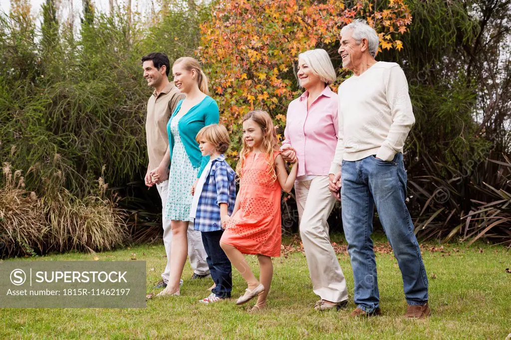 Extended family walking hand in hand in garden