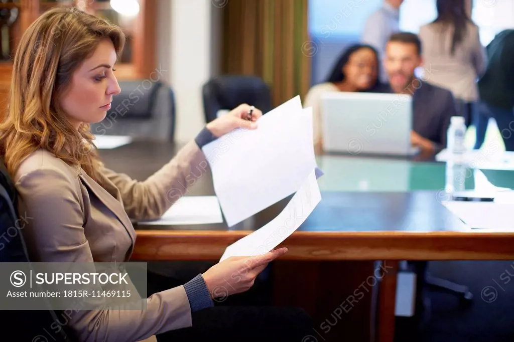 Businesswoman reading document in boardroom