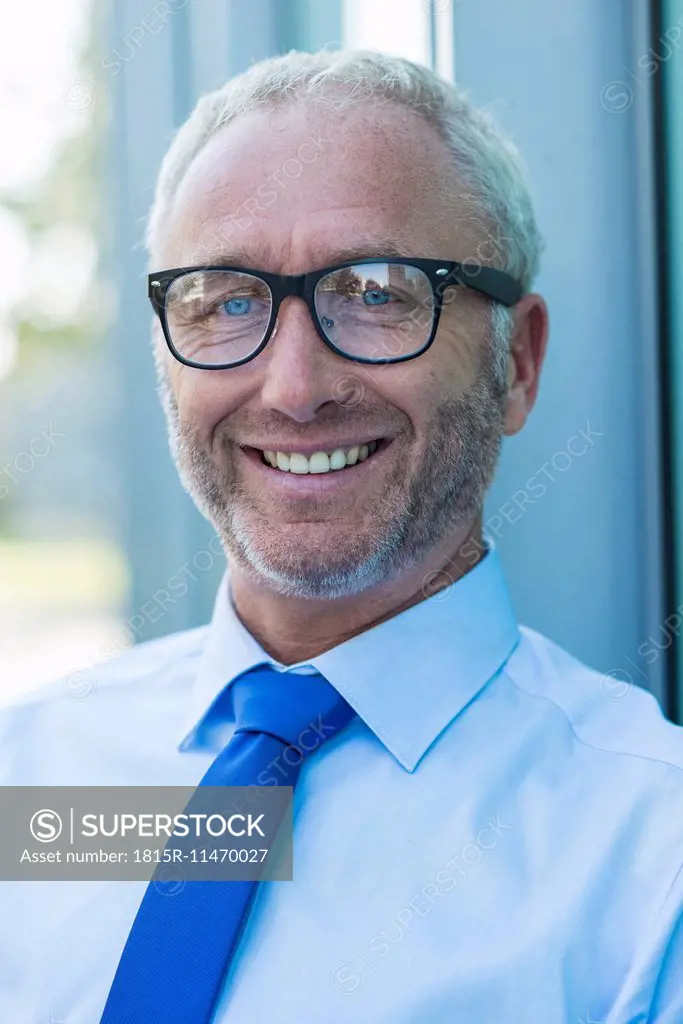 Portrait of smiling businessman outdoors