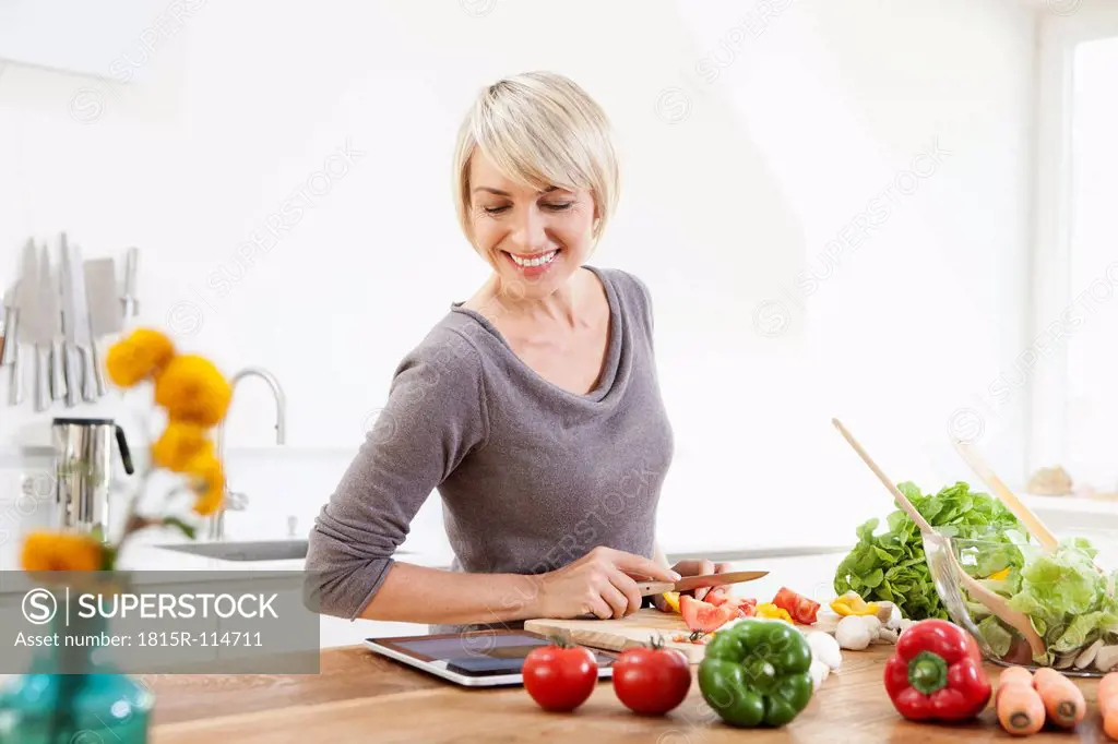 Germany, Bavaria, Munich, Woman preparing food in kitchen