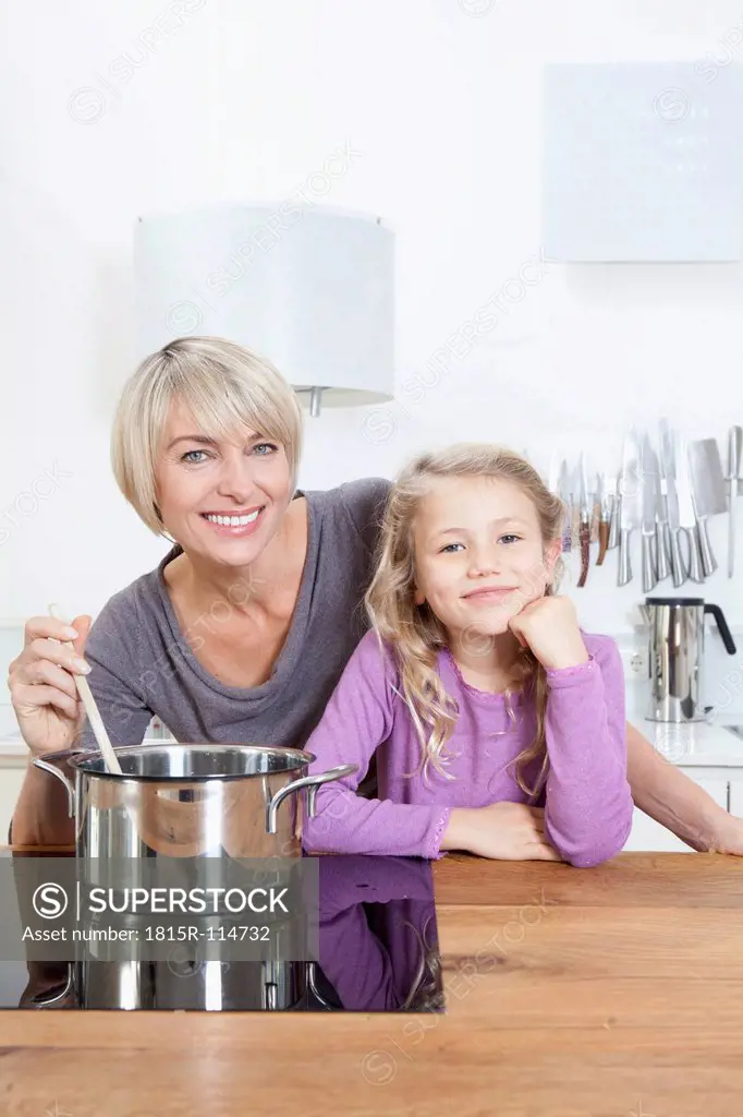 Germany, Bavaria, Munich, Mother and daughter preparing food, smiling, portrait
