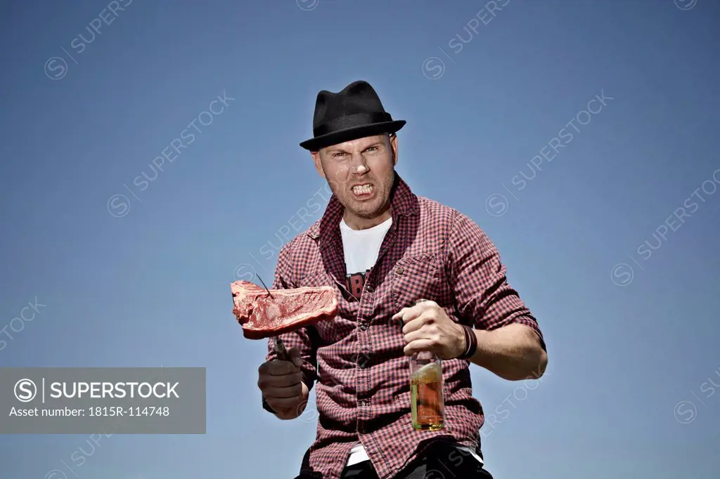 Germany, Cologne, Mature man with meat and beer