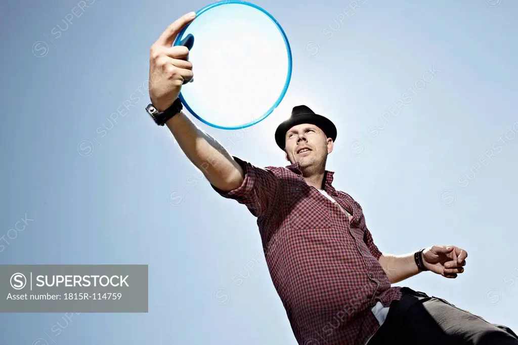 Germany, Cologne, Mature man playing flying disc