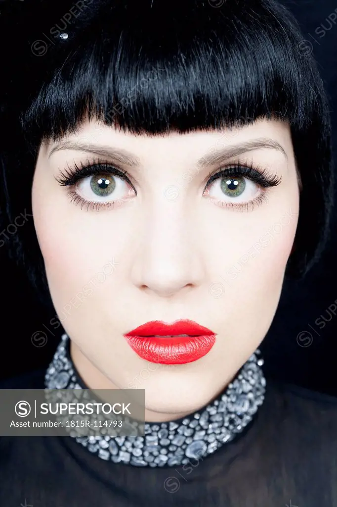Close up of young woman against black background