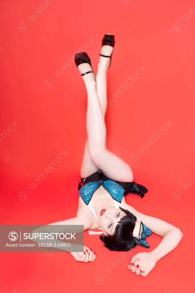 Young woman lying on red background
