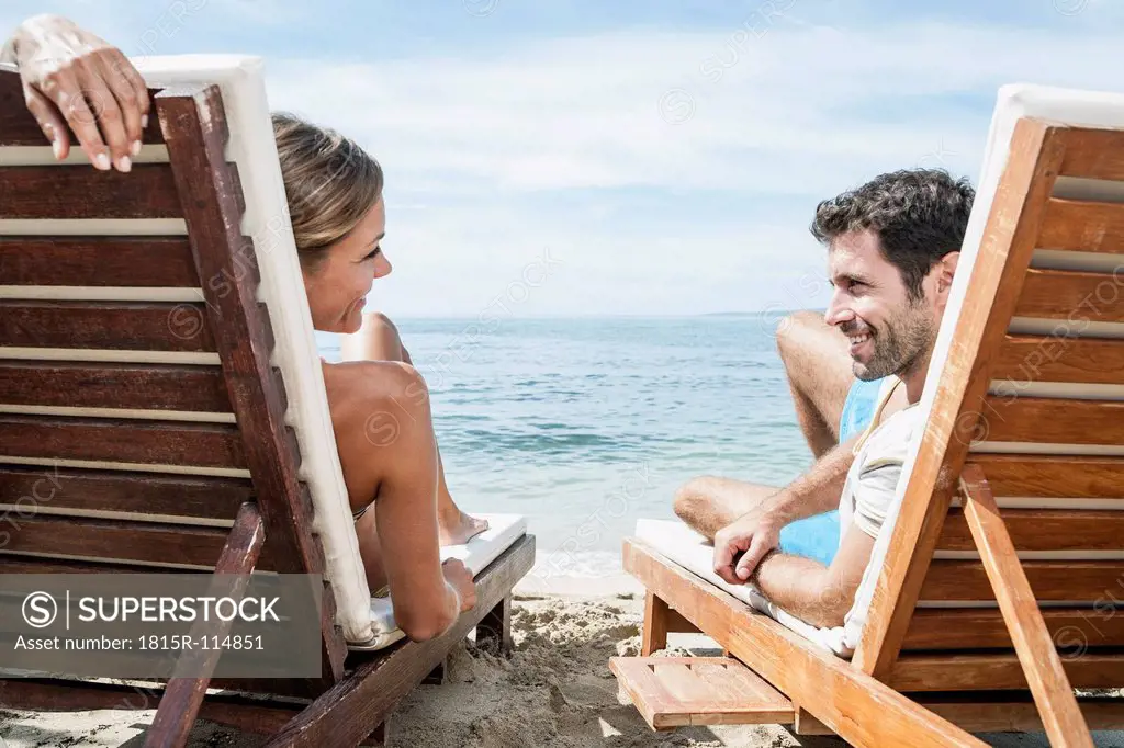 Spain, Mid adult couple relaxing on beach chair