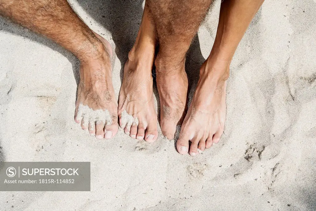Spain, Mid adult couple legs on beach
