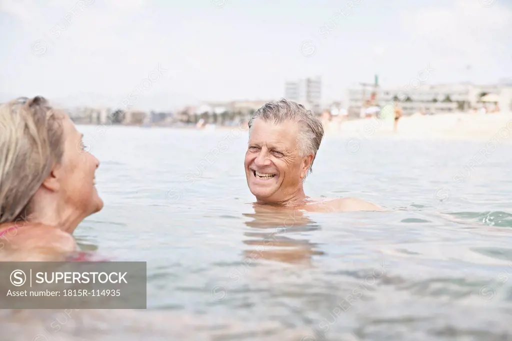 Spain, Senior couple swimming in sea
