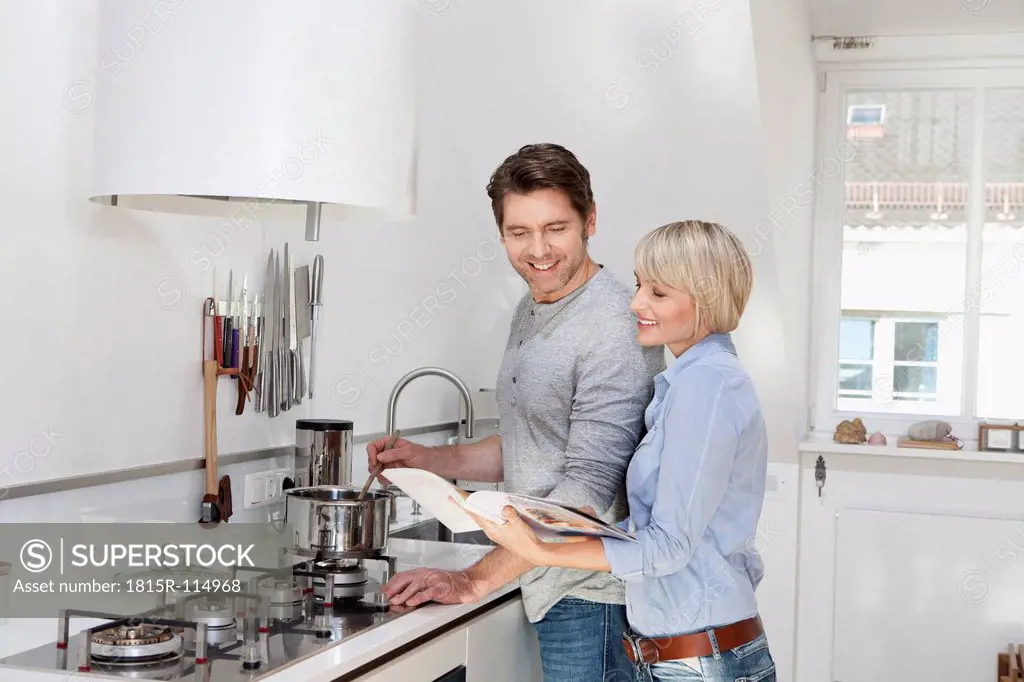 Germany, Bavaria, Munich, Mature couple preparing food in kitchen