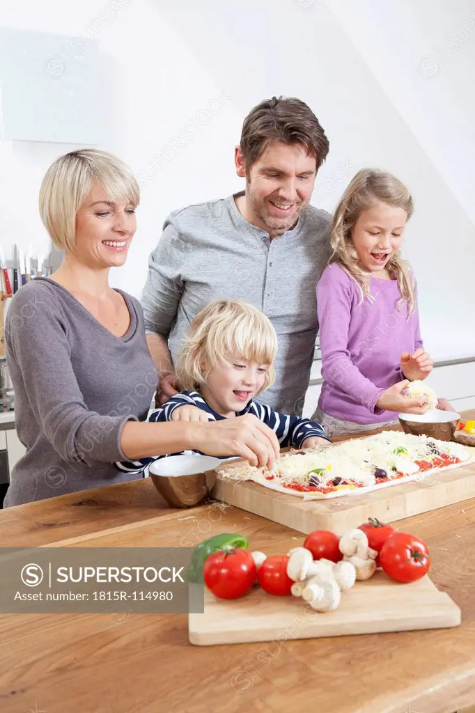 Germany, Bavaria, Munich, Family preparing pizza in kitchen