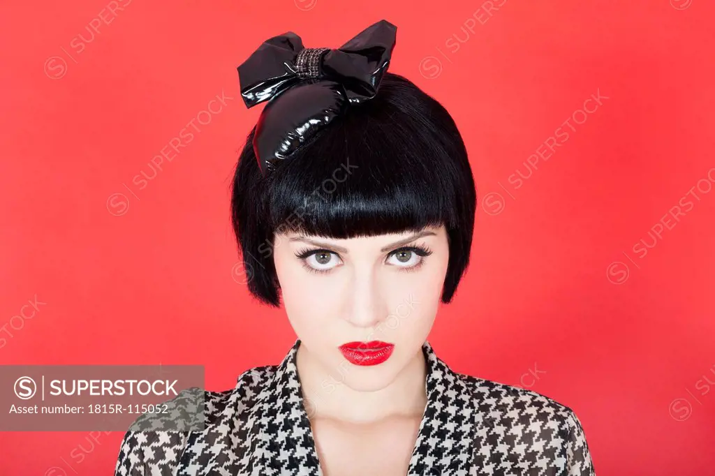 Close up of young woman against red background