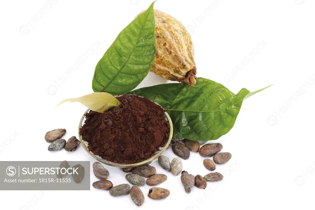 Cocoa powder with beans and leaves, close-up