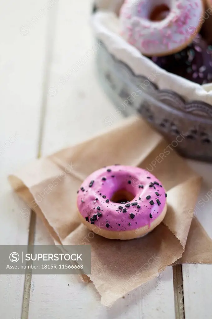 Pink, chocolate and white donuts with sprinkles, studio