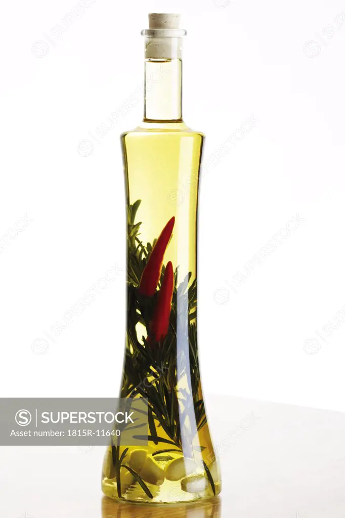Bottle of olive oil with herbs and spices, close-up