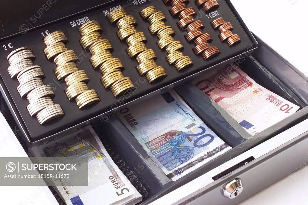 Cash box filled with coins and banknotes, elevated view, close-up
