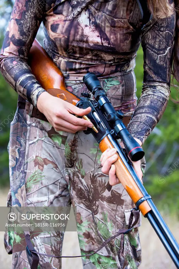USA, Texas, Young woman with hunting rifle