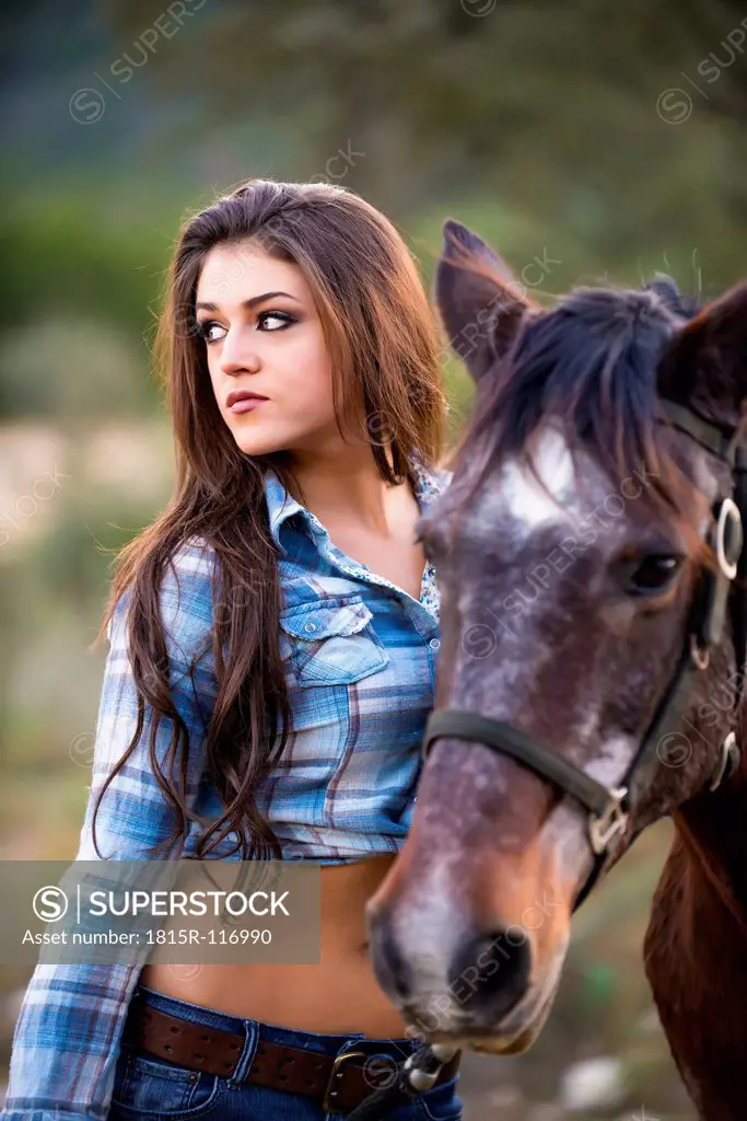 USA, Texas, Cowgirl standing with horse