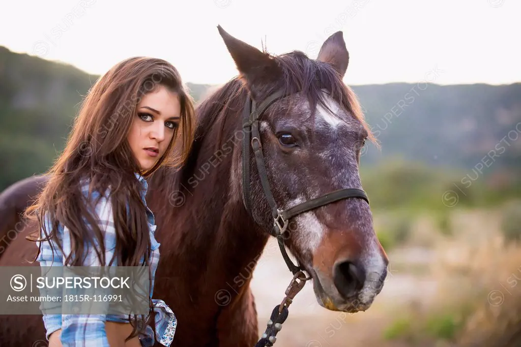 USA, Texas, Cowgirl standing with horse