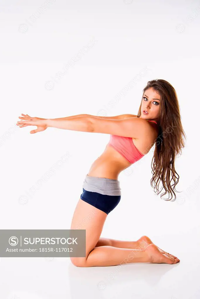 Young woman exercising on white background