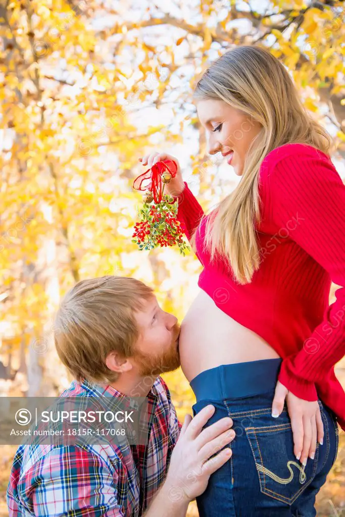 USA, Texas, Man kissing pregnant womans belly, close up
